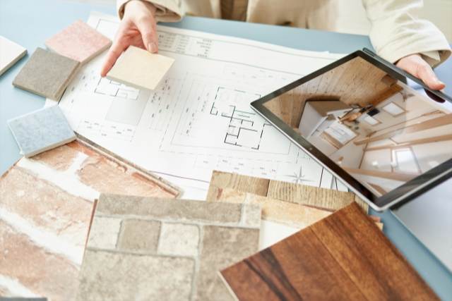 間取り図と壁紙のサンプルと内装をタブレットで確認している