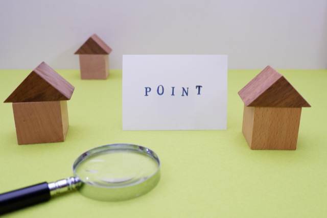 3つの家の模型と虫眼鏡とポイントと書かれた紙