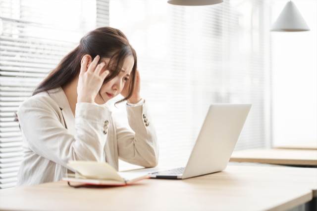 頭を抱えて悩む女性